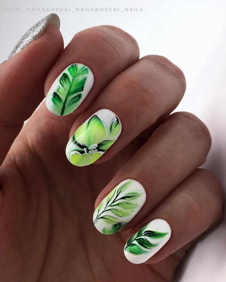 Белый маникюр на овальные ногти средней длины с рисунками зеленых тропических листьев
