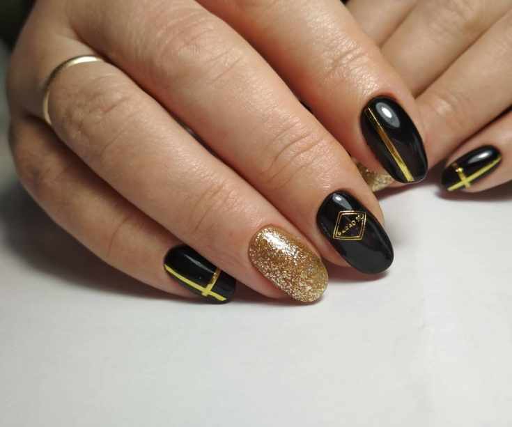 Черный с золотым маникюр на миндальные ногти средней длины с глиттером, лентами и наклейками